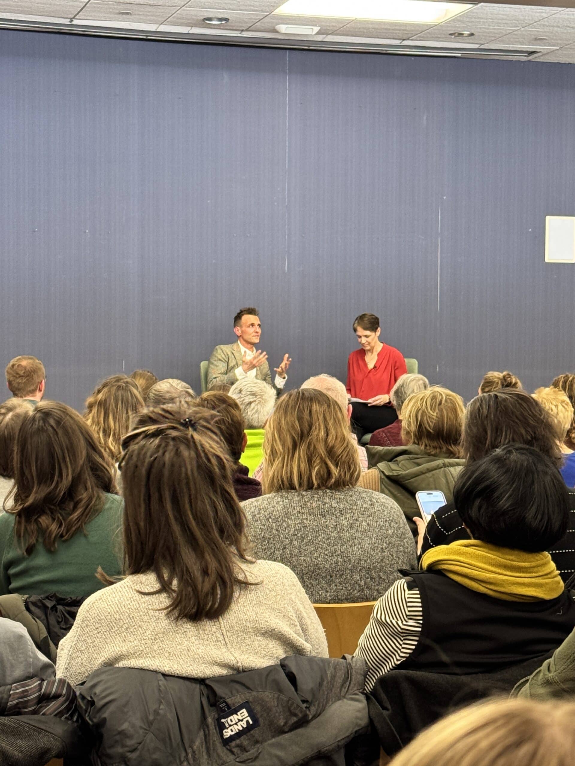 Kaleb Wyse speaking with Charity Nebbe at the Iowa City Public Library.