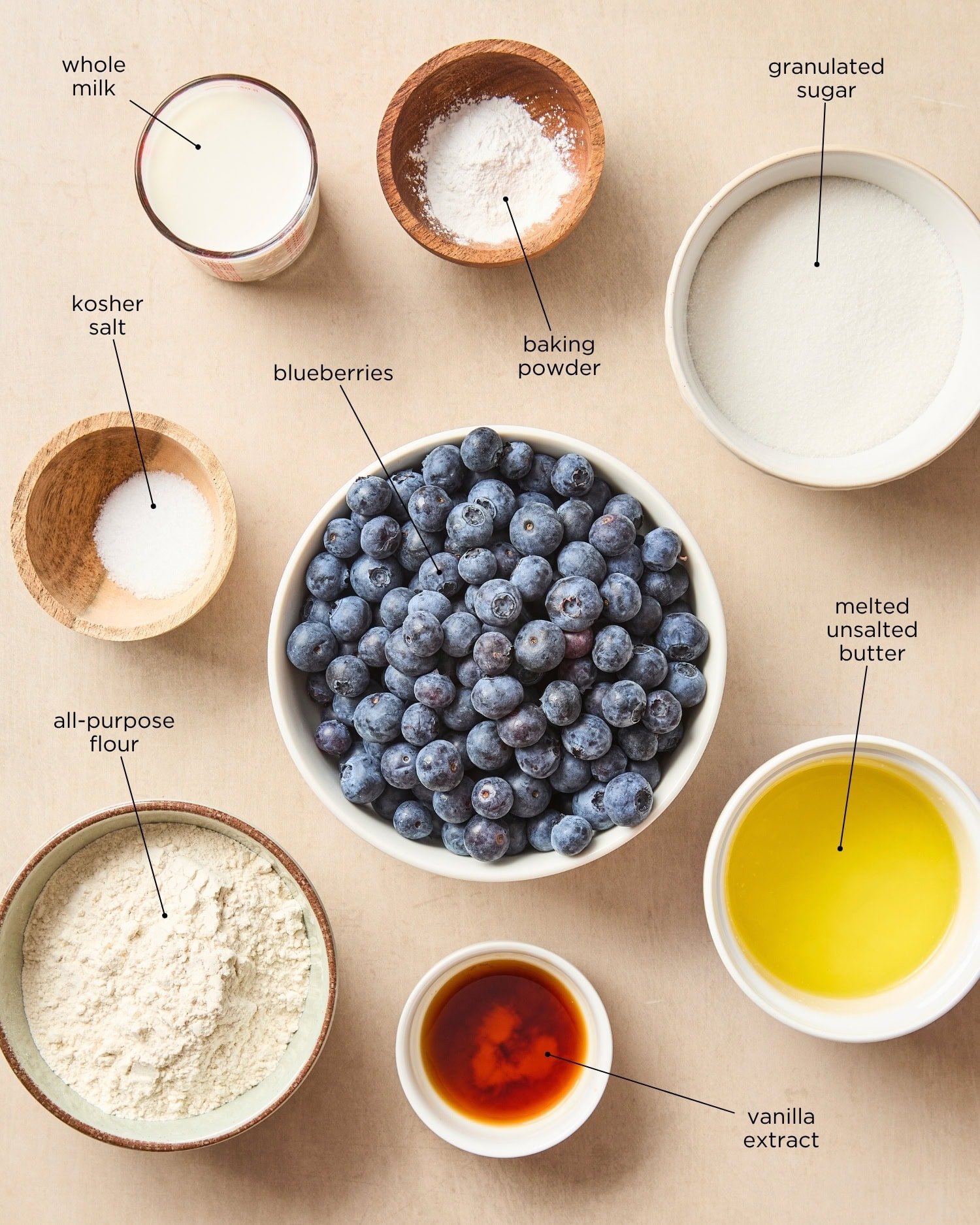 Surface with ingredients needed for blueberry cobbler including sugar, flour, butter, and more.