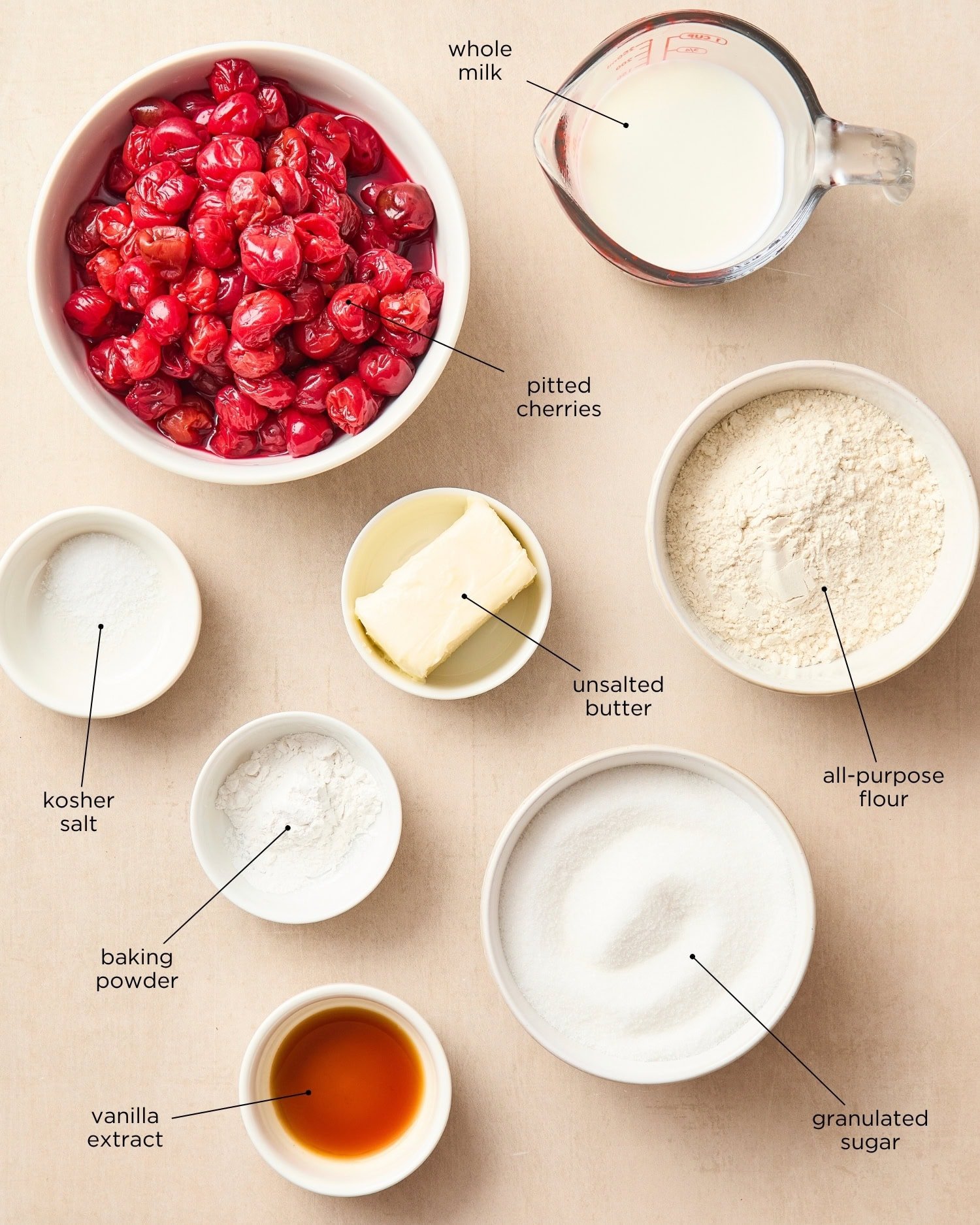 Surface filled with pitted cherries, flour, sugar, and more for cherry cobbler recipe.