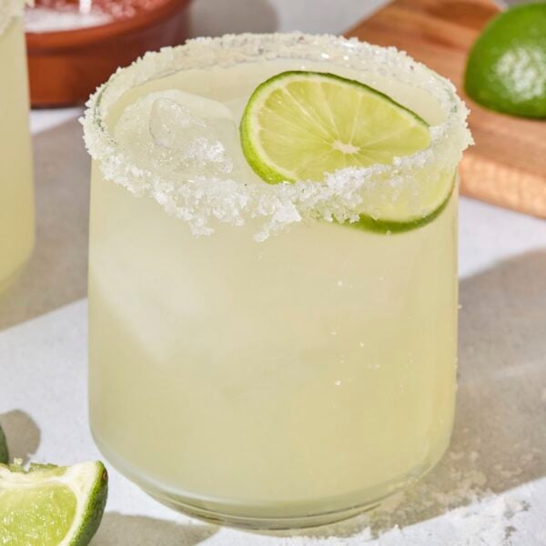 Cocktail glass with a classic margarita and lime wedge.