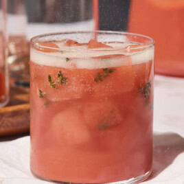 Grapefruit gin punch topped with sparkling wine with ice cubes made with fresh thyme leaves.