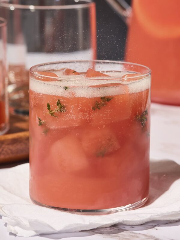 Grapefruit gin punch topped with sparkling wine with ice cubes made with fresh thyme leaves.