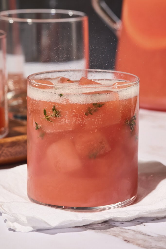 Grapefruit gin punch topped with sparkling wine with ice cubes made with fresh thyme leaves.