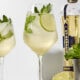 Wine glass filled with Hugo Spritz with mint sprig and lime wheel.