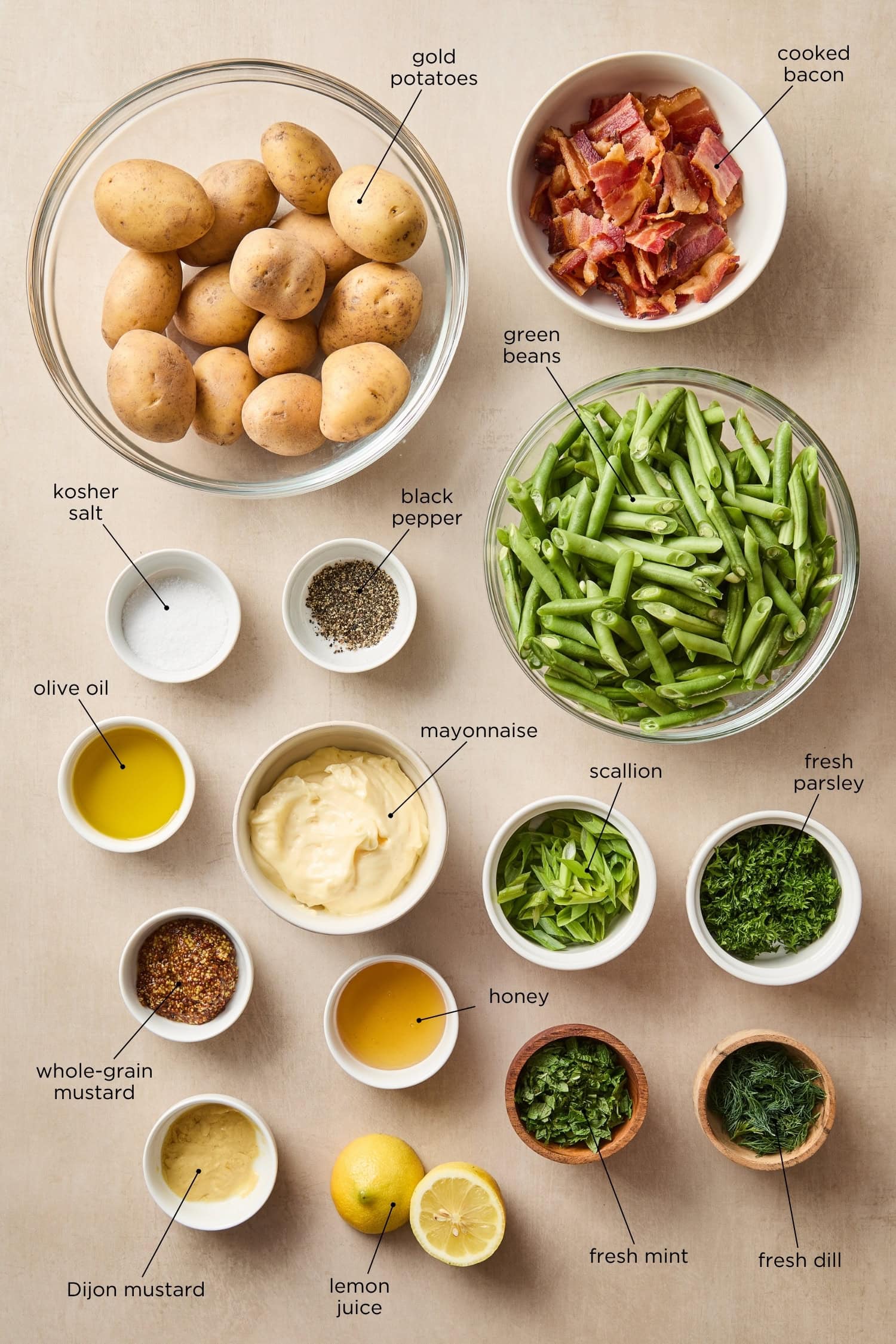 Surface with ingredients for a potato salad including bacon, green beans, potatoes, and ingredients for a dressing.