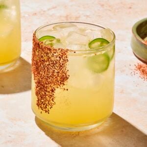 Glass filled with spicy margarita with seasoning on glass as garnish.