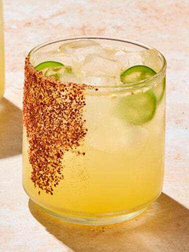 Glass filled with spicy margarita with seasoning on glass as garnish.