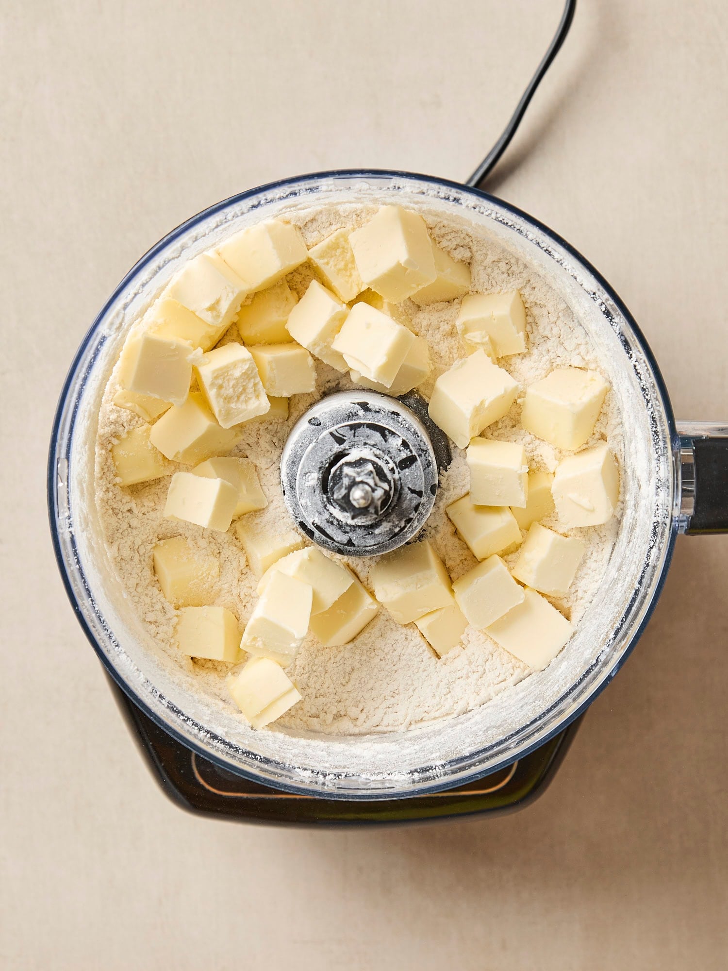 Food processor with cubes of butter with flour for a pie crust recipe.