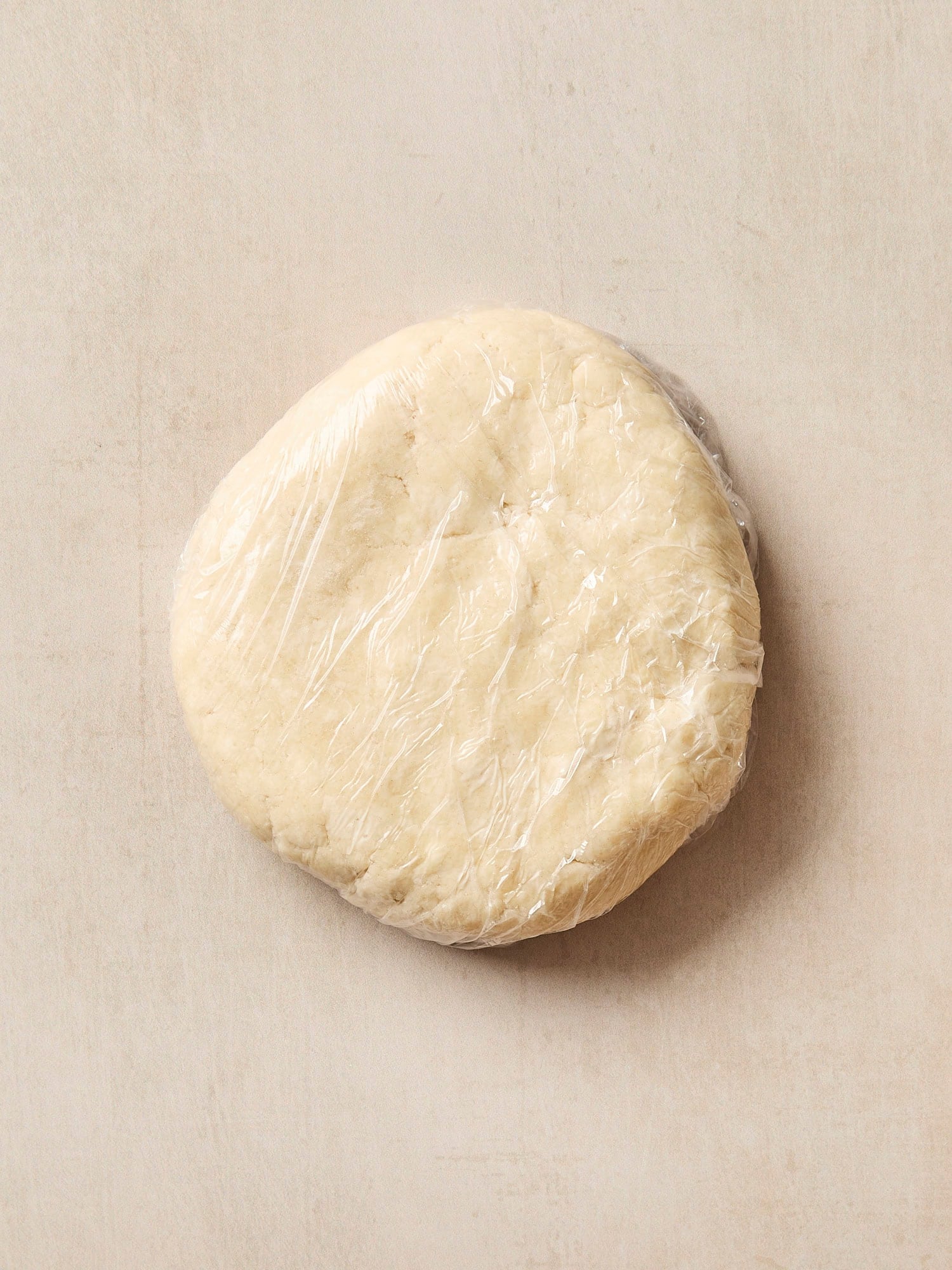 Pie dough wrapped in plastic wrap after being prepared.