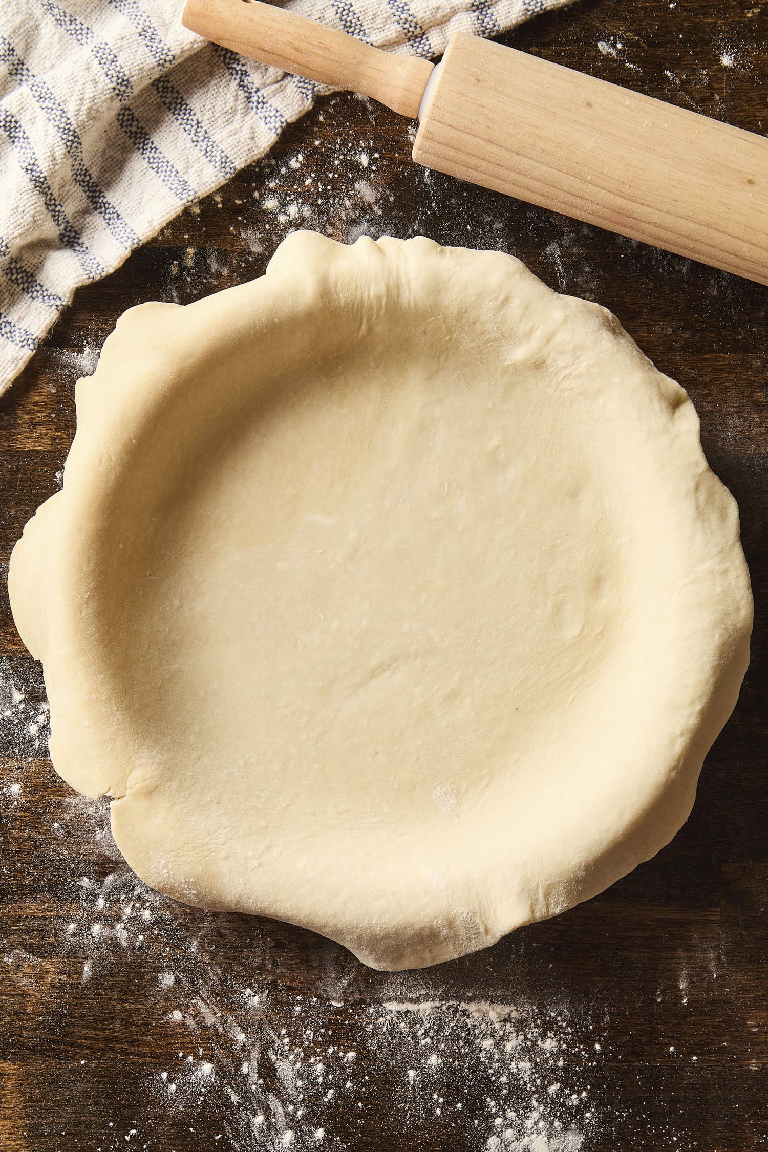 Rolled out pie crust in a pie dish before being crimped.