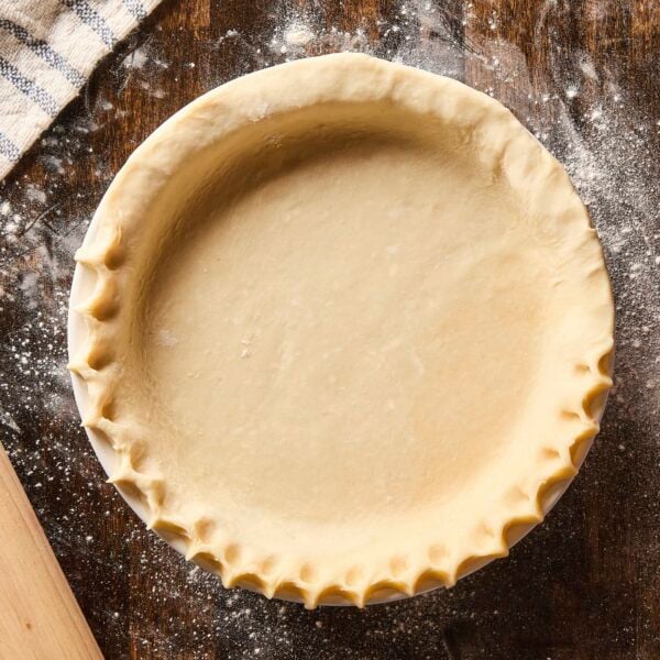 Pie crust with crimped edge before being baked.
