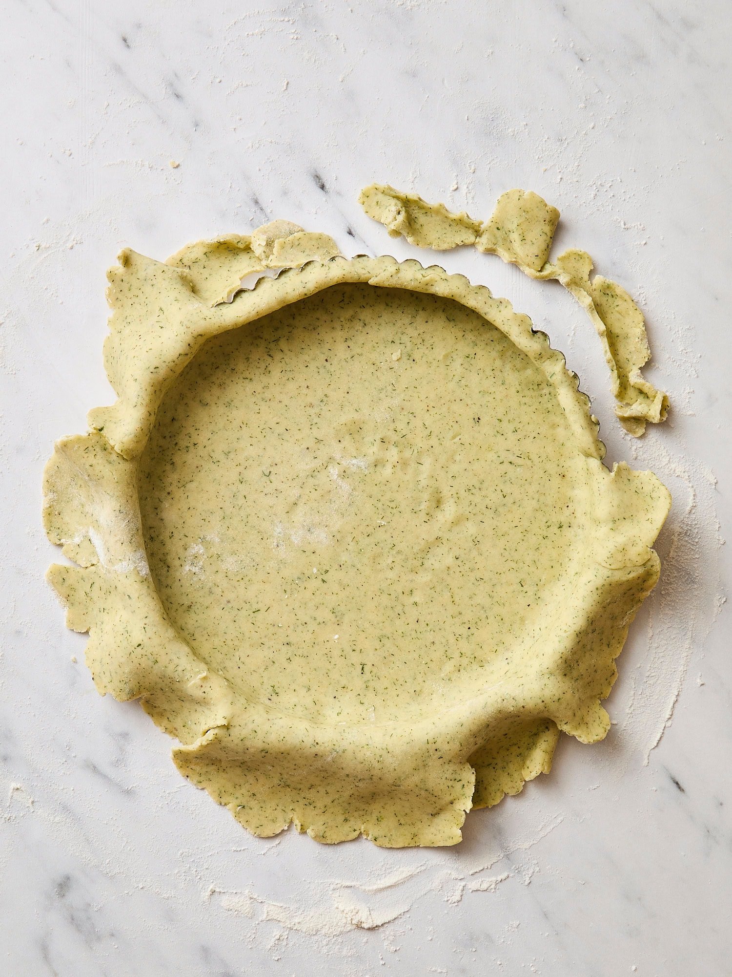 Lightly green colored dough pressed into a tin pan for a crust.