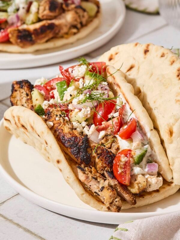Pita with chicken gyros topped with Greek salad, feta, and tzatziki sauce.
