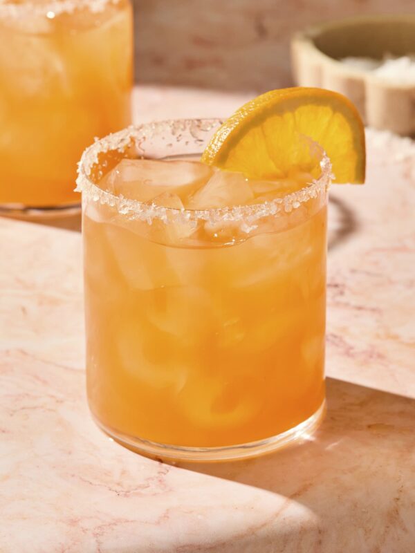 Orange colored Italian margarita in a glass with an orange slice.