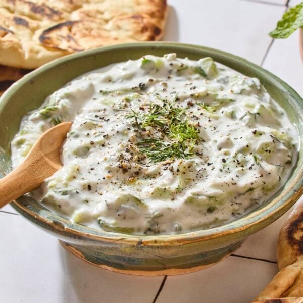 Bowl filled with tzatziki sauce with dill on top.