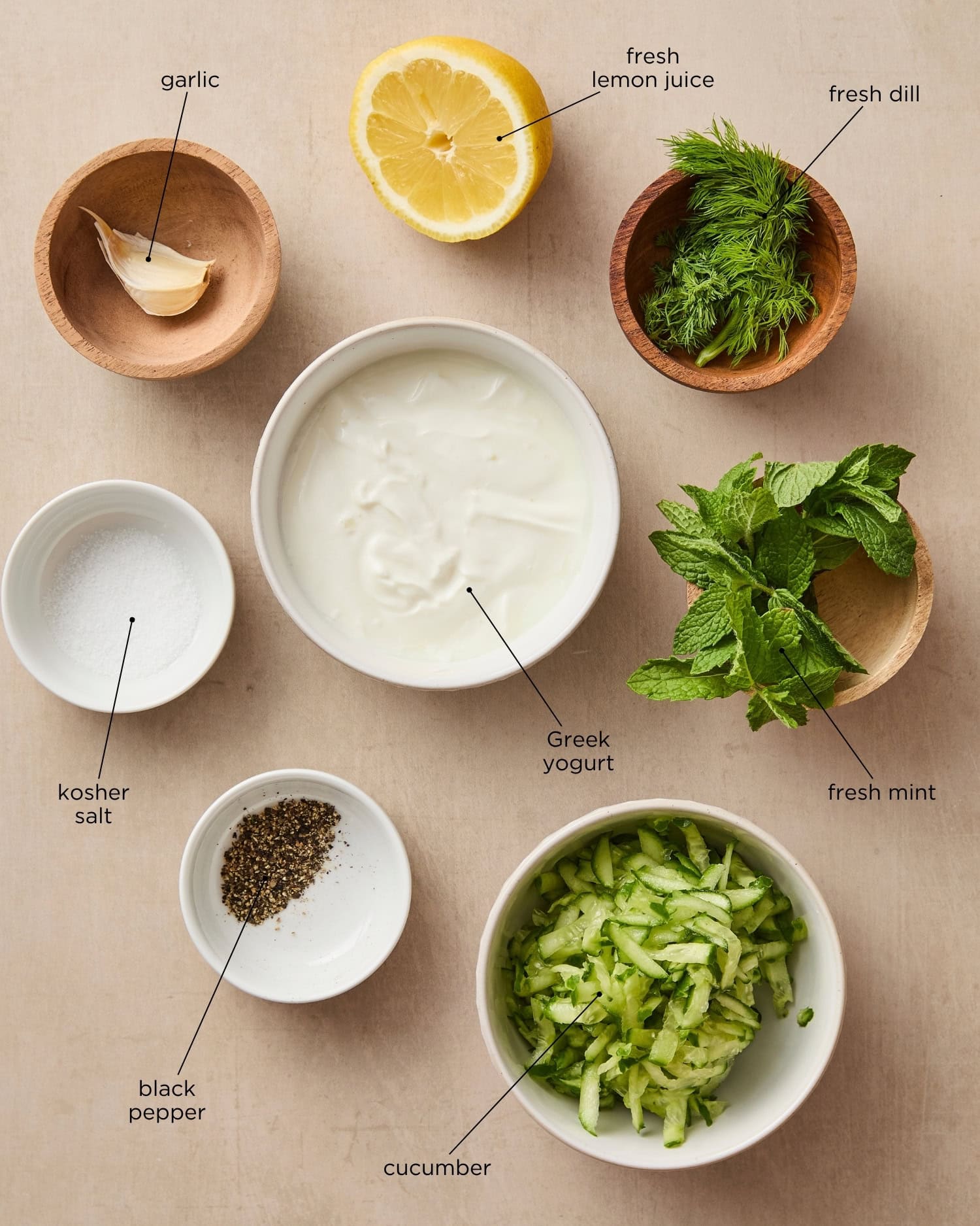 Surface with ingredients needed for a homemade tzatziki sauce.