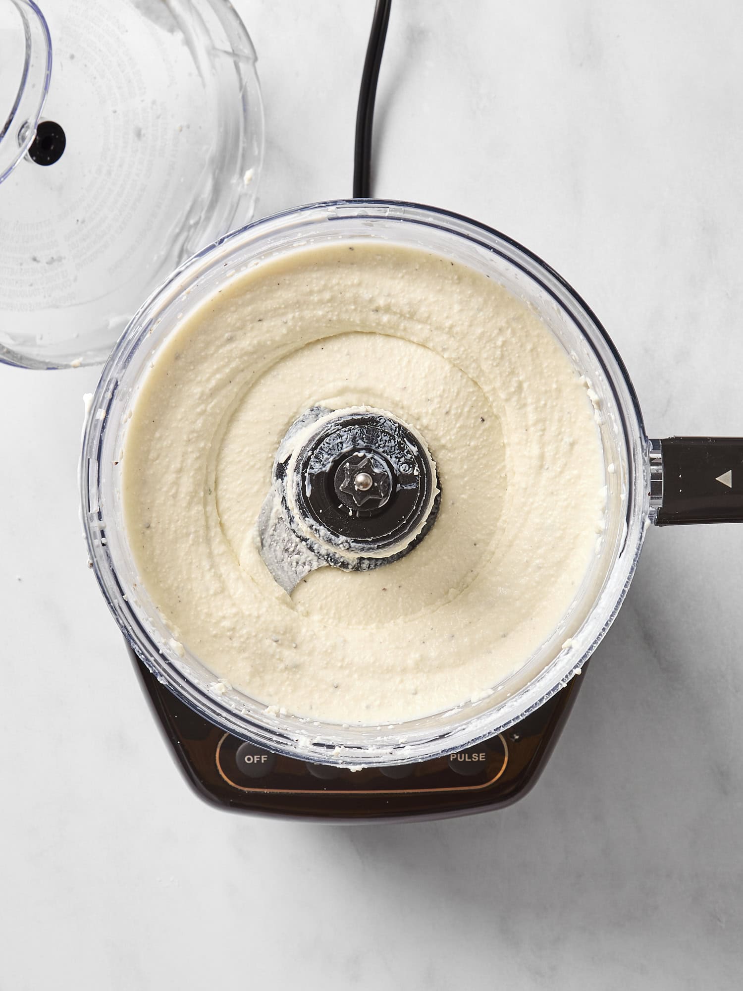 Food processor with feta dip after being processed.