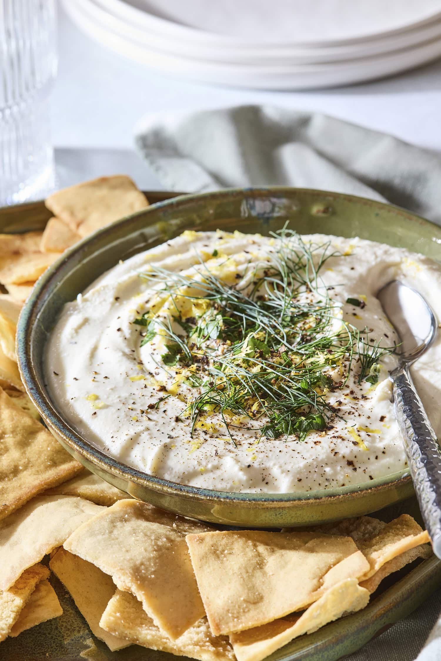 Bowl with whipped feta dip with spoon scooping out serving.