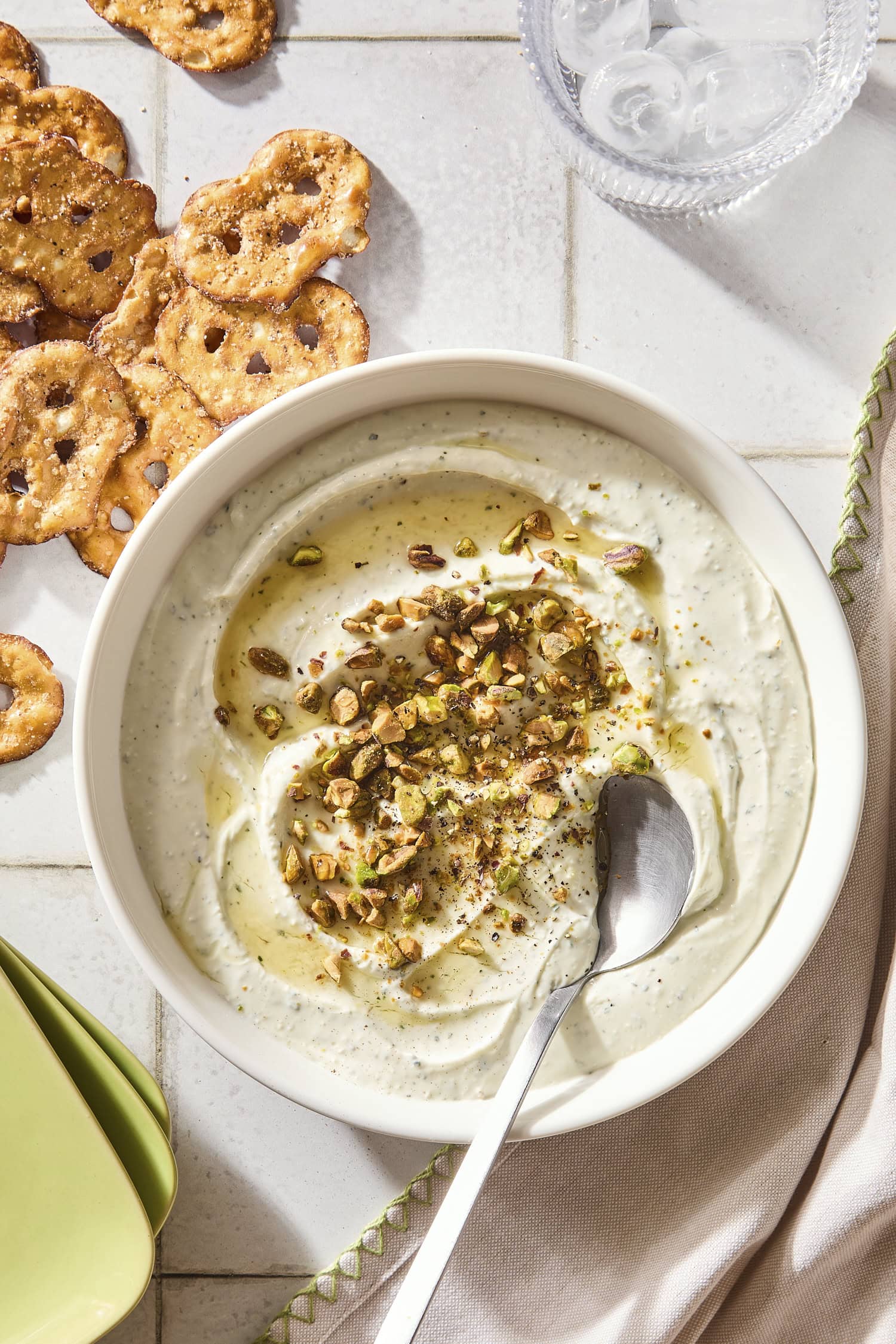 Bowl with goat cheese dip with pretzels to the side and topped with pistachios and hot honey.