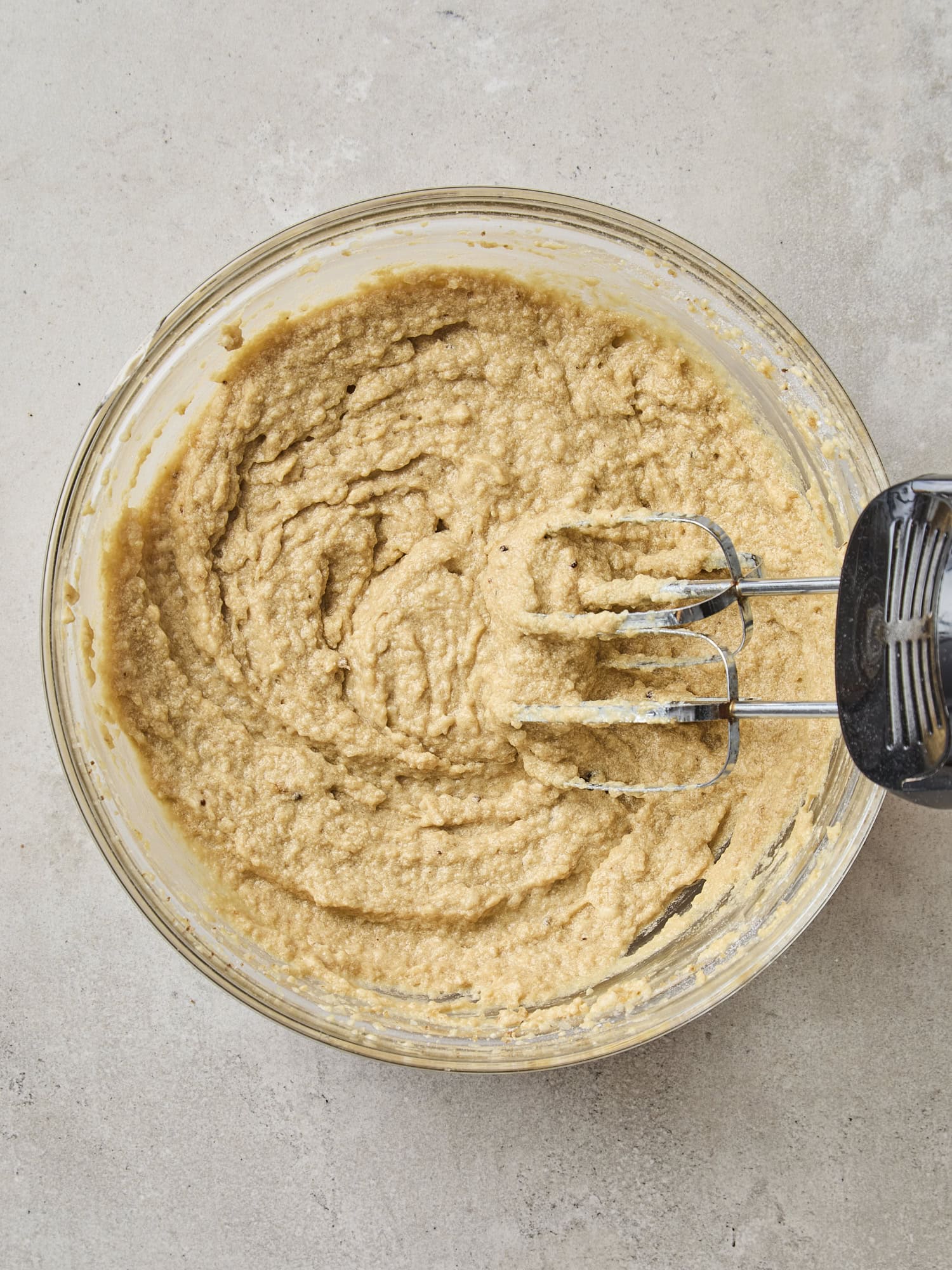 Glass bowl with wet ingredients mixed together for applesauce cake.