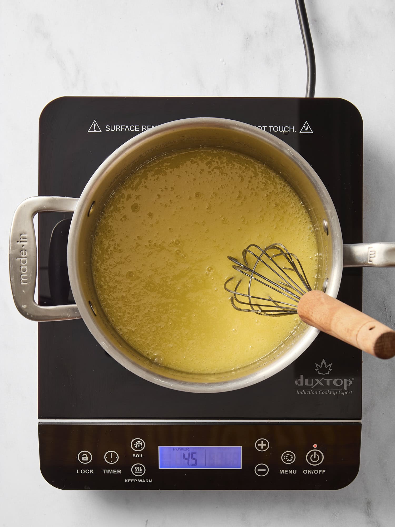 Pan with melted butter and sugar cooking with a whisk.