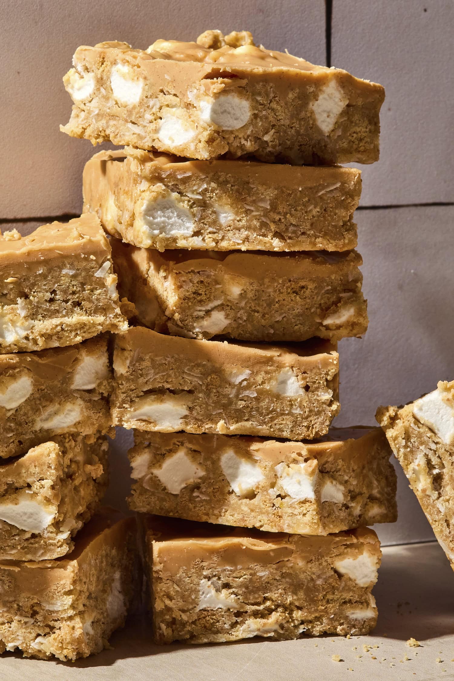 Stacked pieces of butterscotch bars on a countertop with pieces of marshmallow inside.