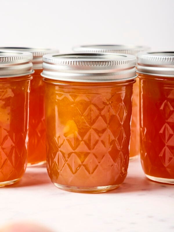 Peach jam in a glass jar.