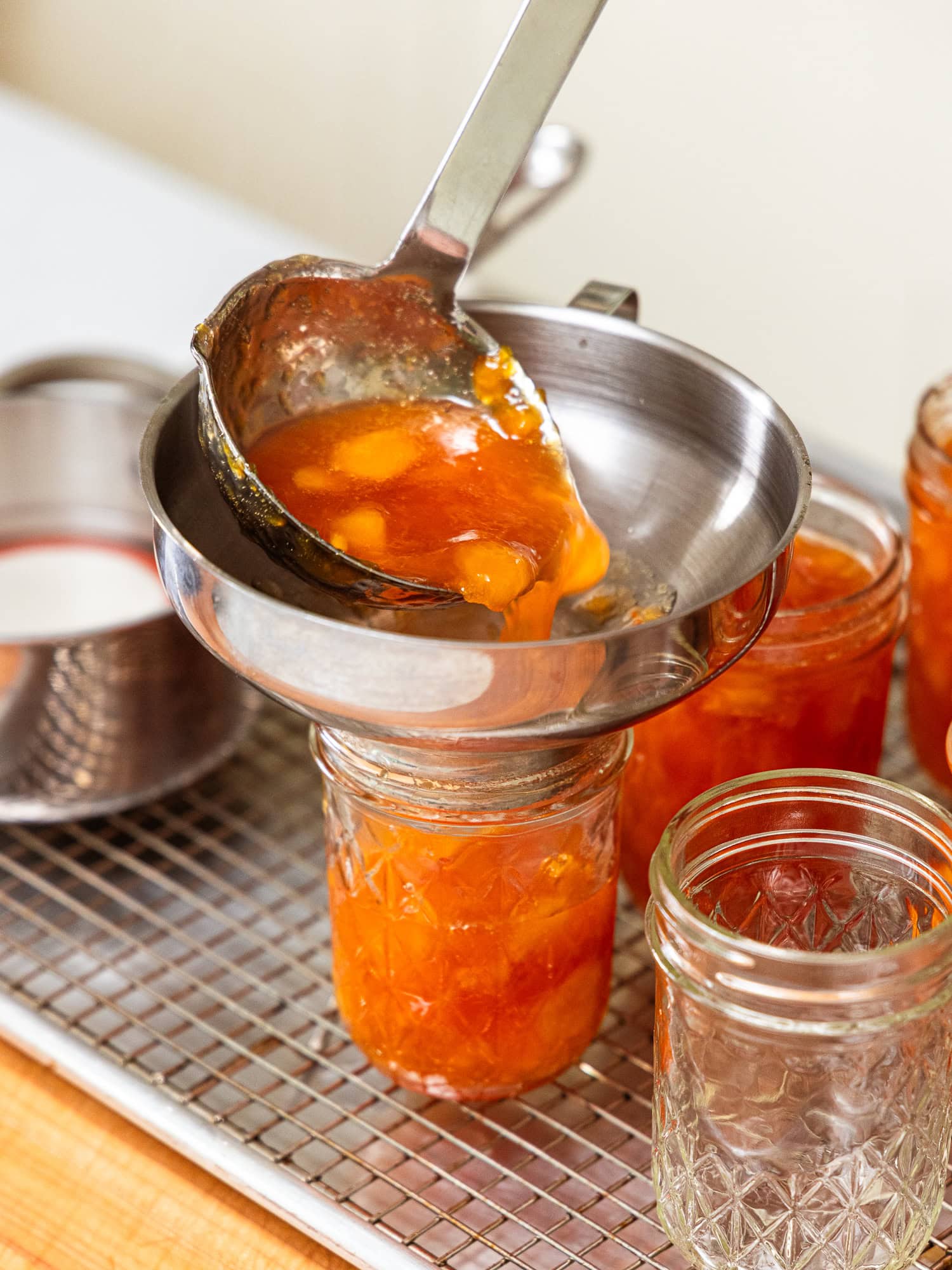 Adding peach jam to jars.
