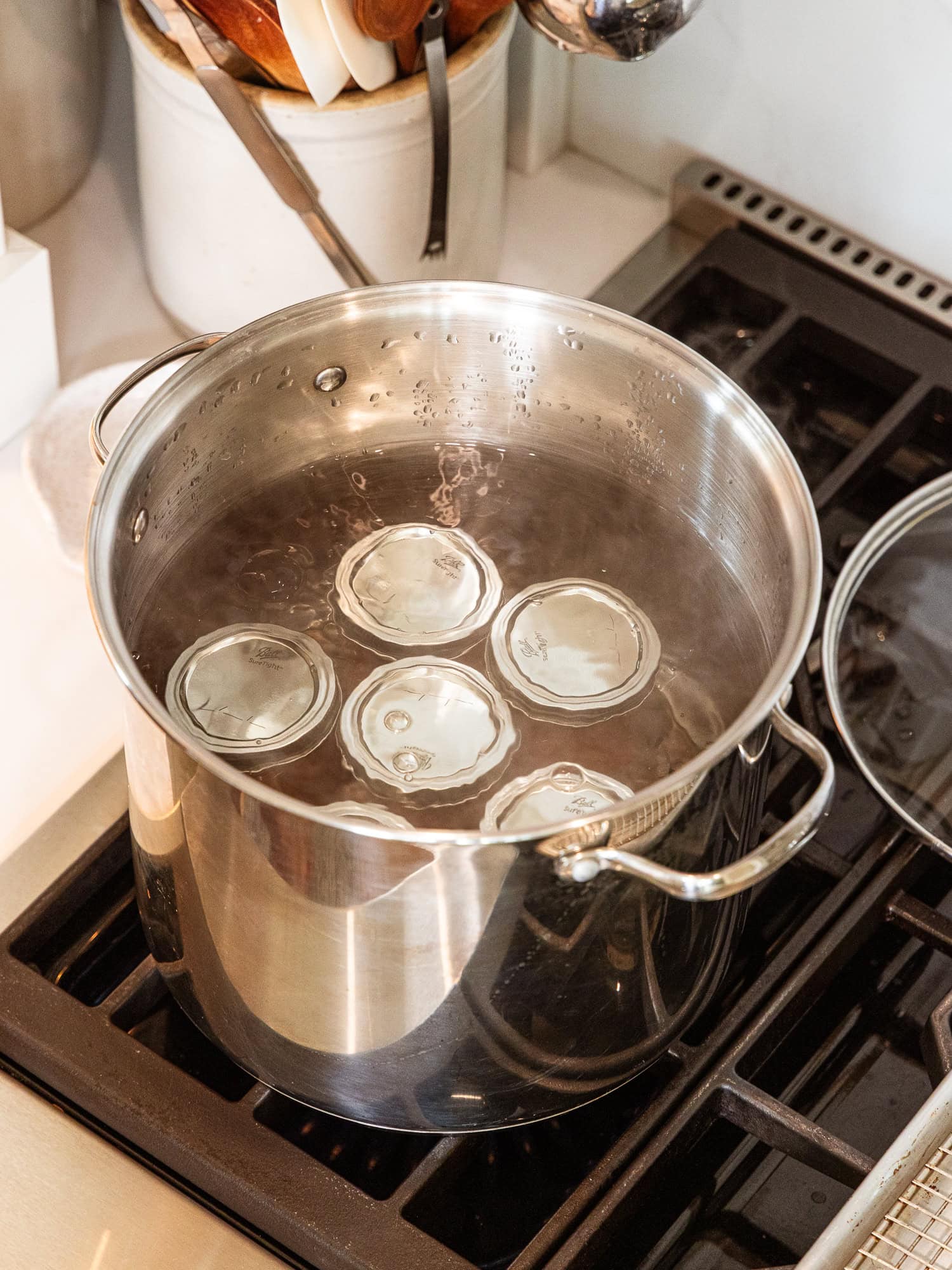 Peach jam jars sealing in a water bath.