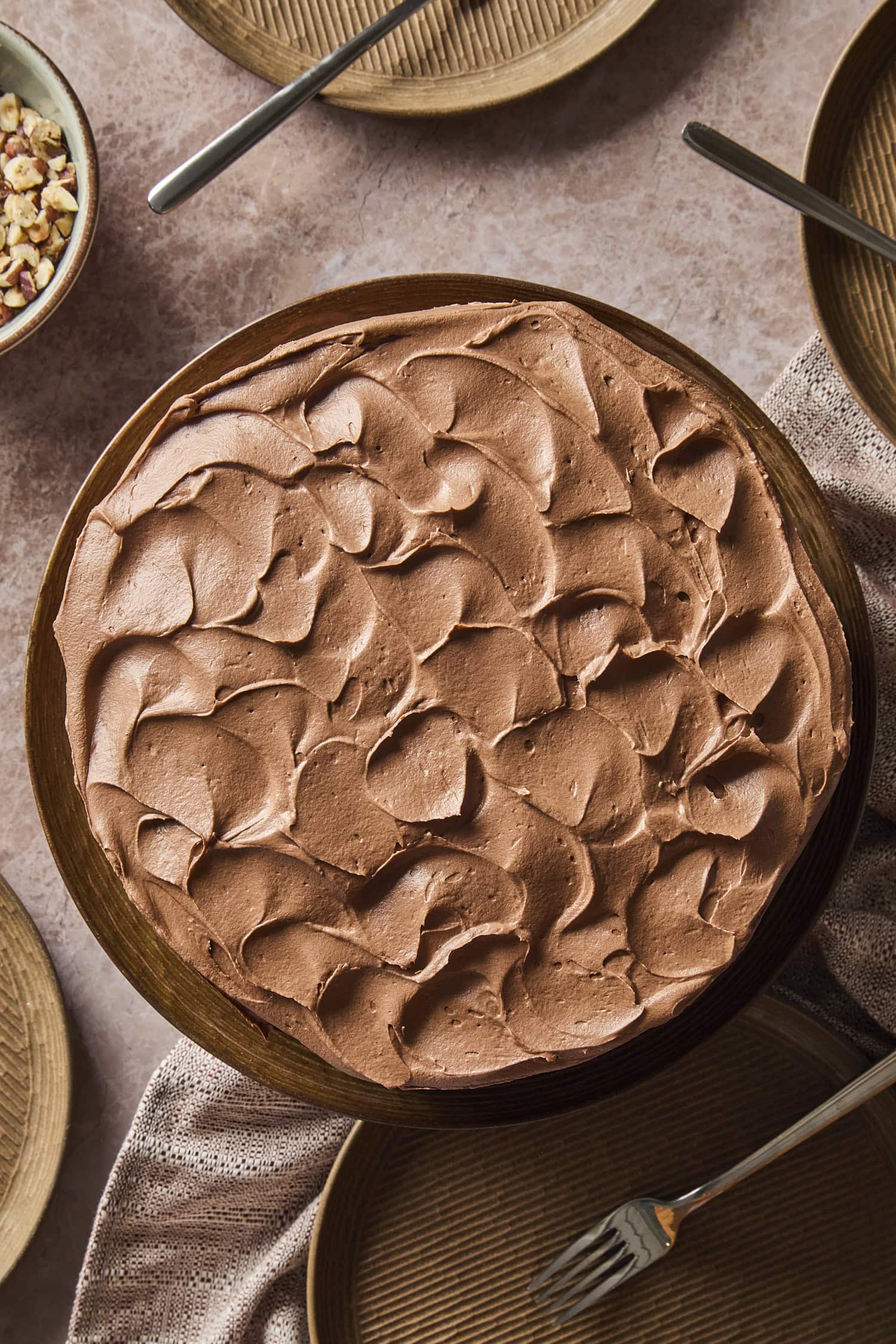 Frosted chocolate cake on a cake plate.