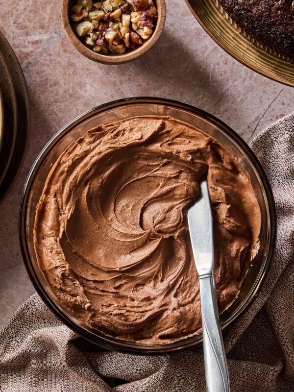 Swirled chocolate frosting with knife resting in frosting ready to be spread.