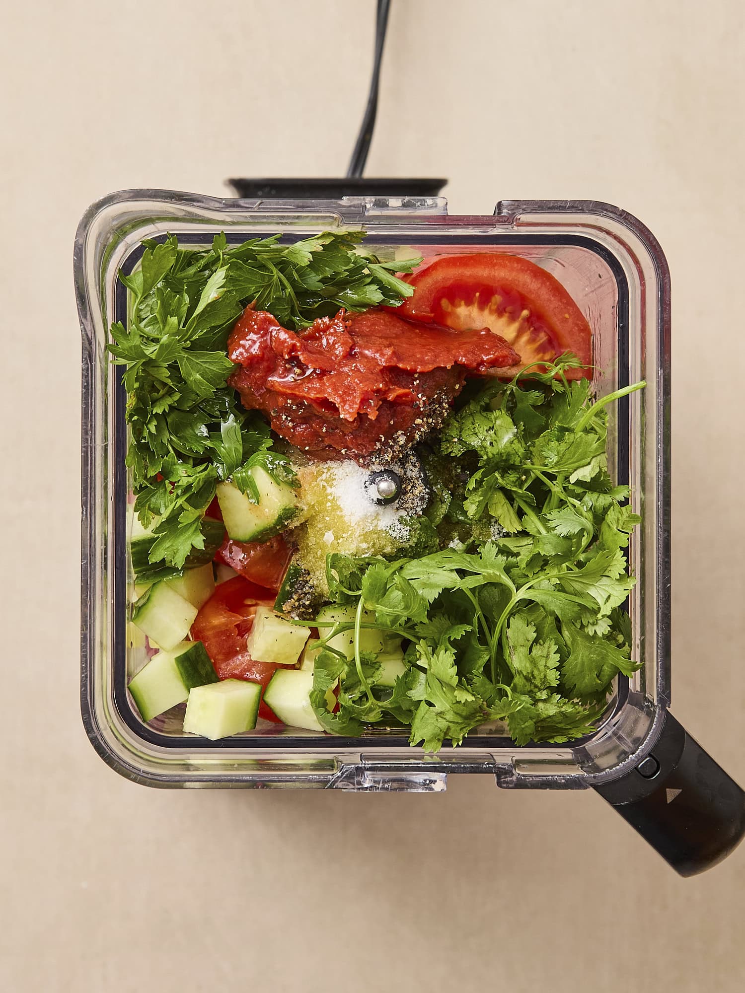 Blender filled with ingredients needed for gazpacho before blending.