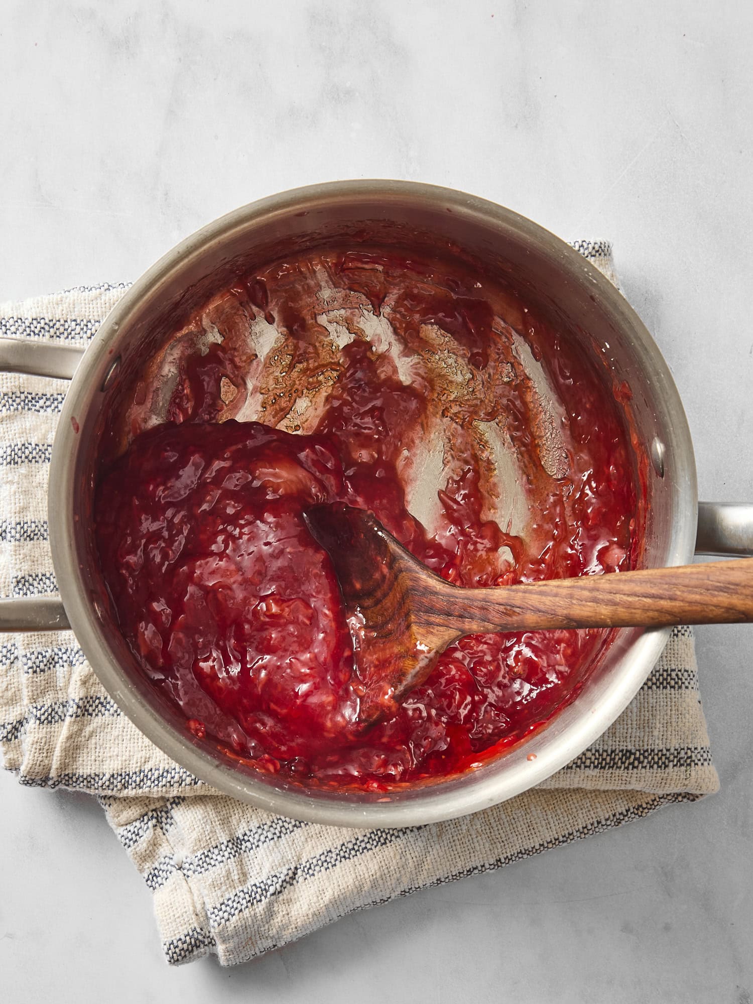 Saucepan filled with filling for a strawberry pie.