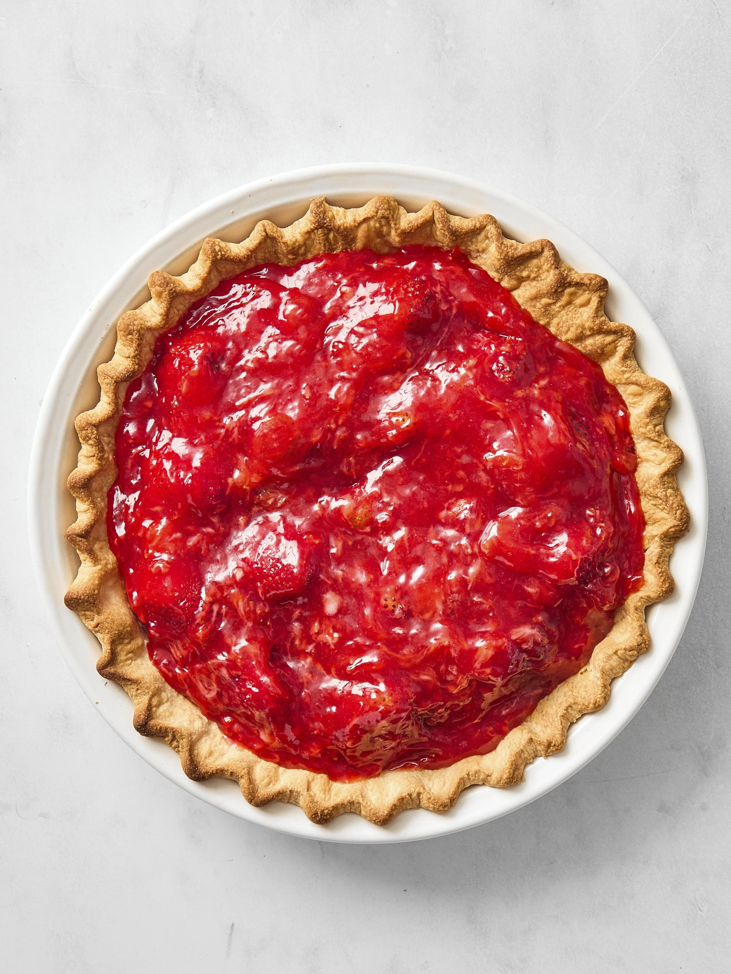 Baked pie crust with strawberry filling inside after being poured together.