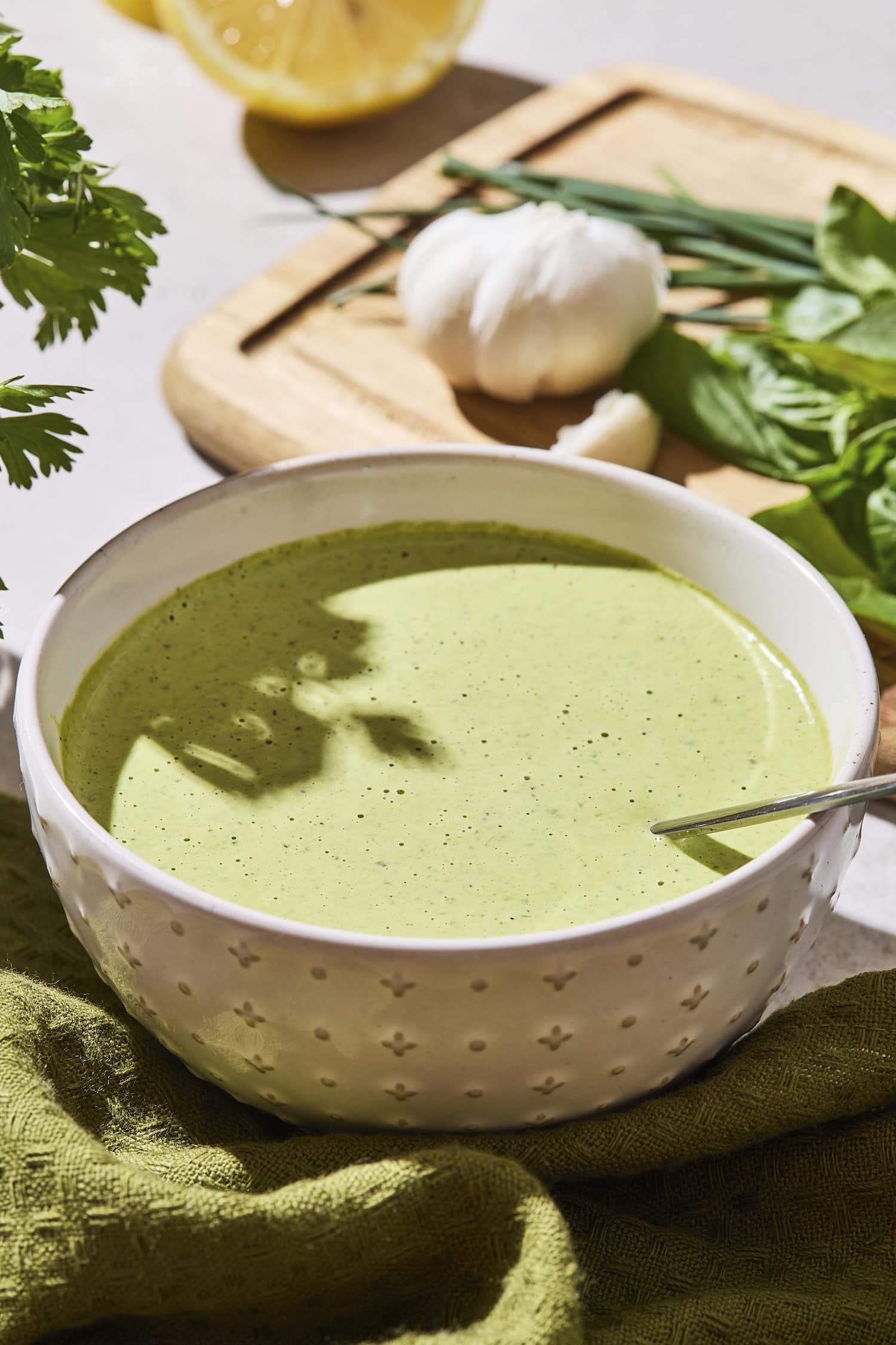 White bowl with green goddess dressing for a salad.