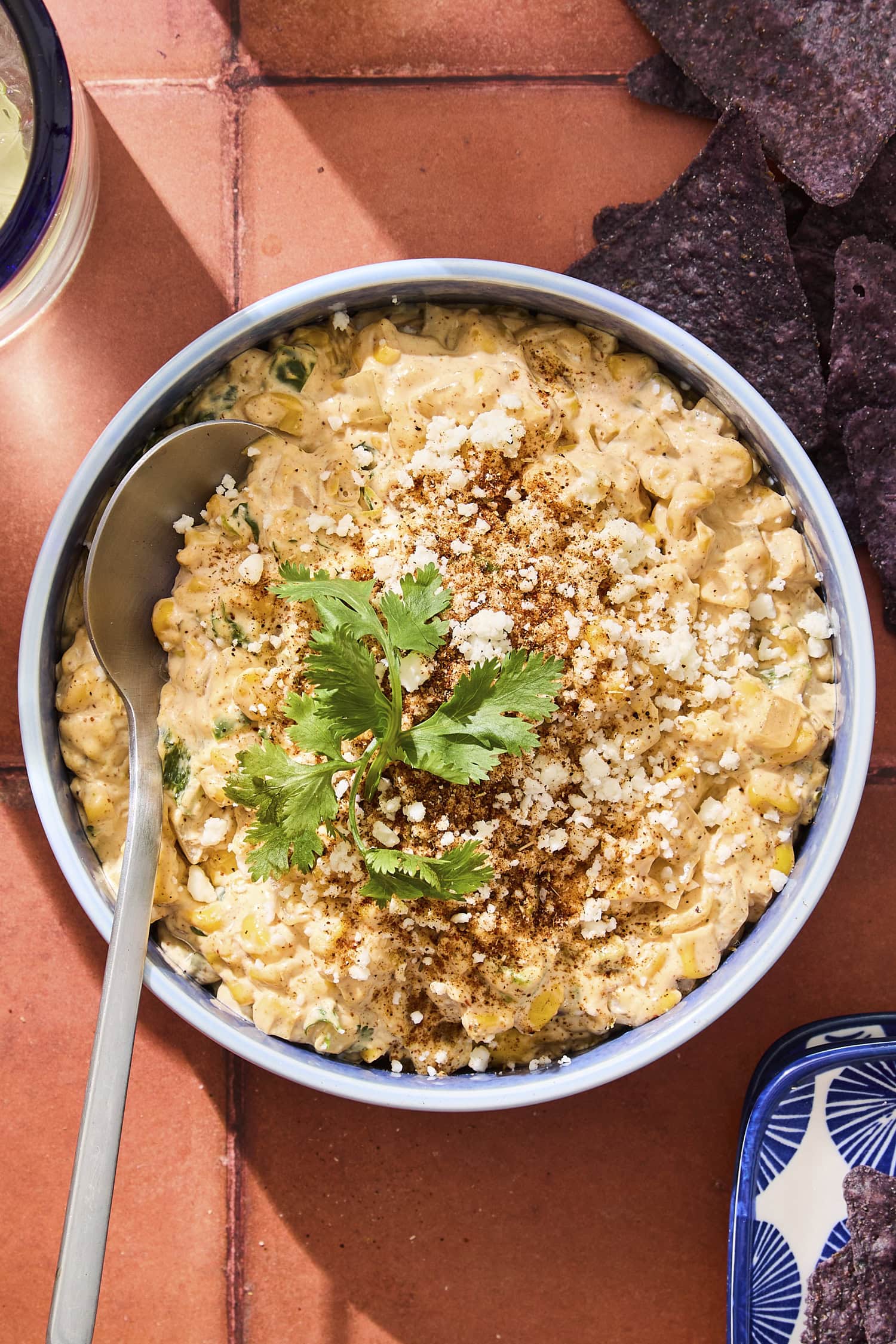 Bowl filled with street corn dip with Cotija cheese and cilantro sprinkled on top.