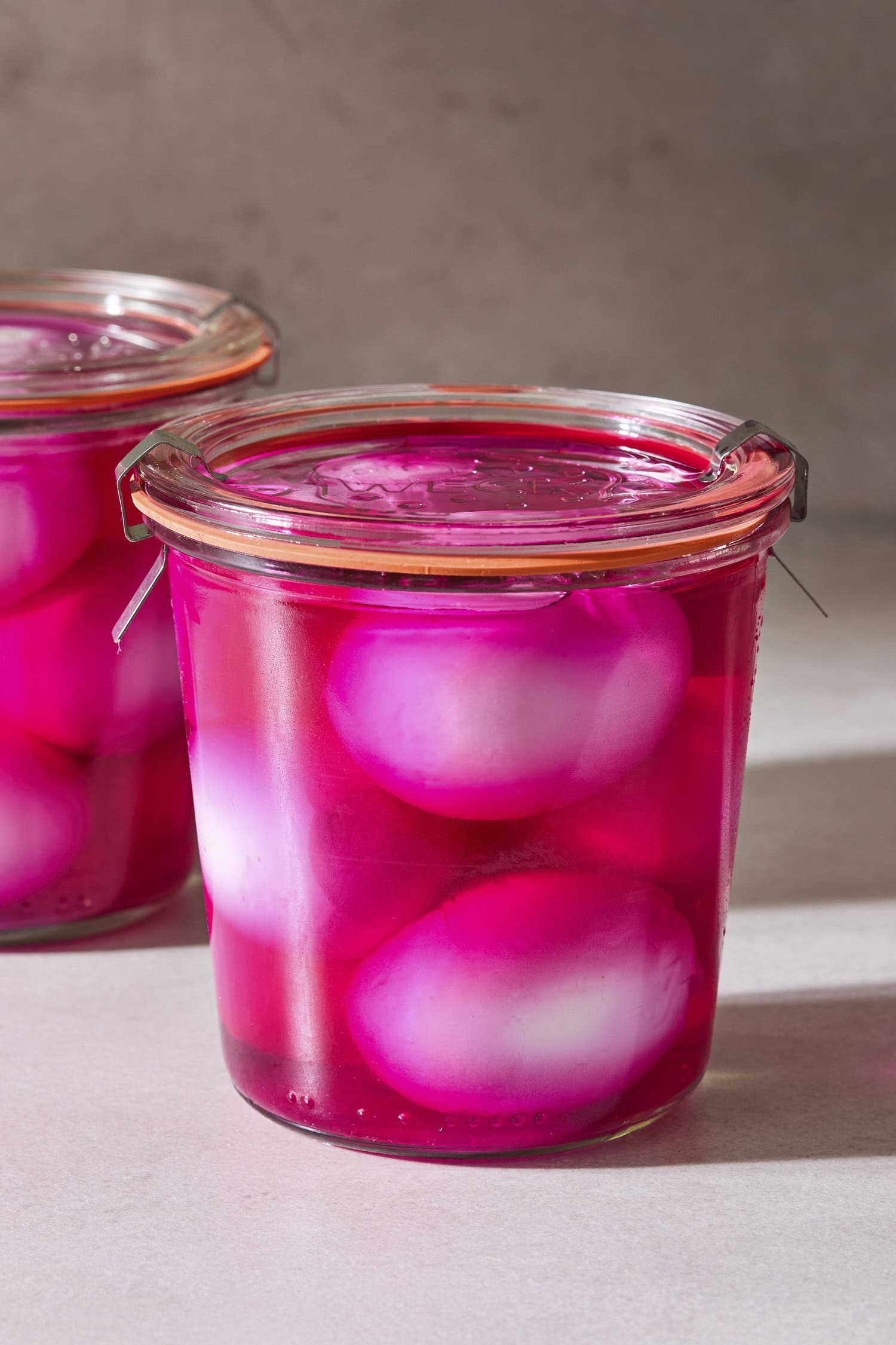 Weck jar filled with pink colored liquid with white hard-boiled eggs inside.