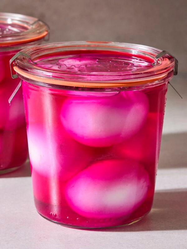 Weck jar filled with red colored pickled eggs.