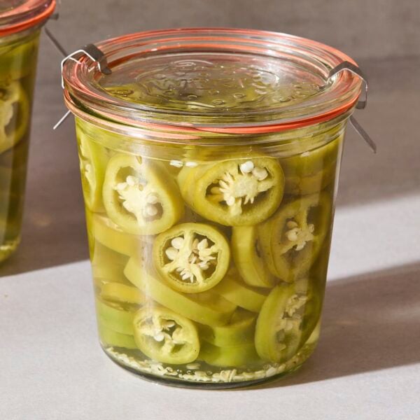 A jar of quick-pickled jalapeños sits on the counter.