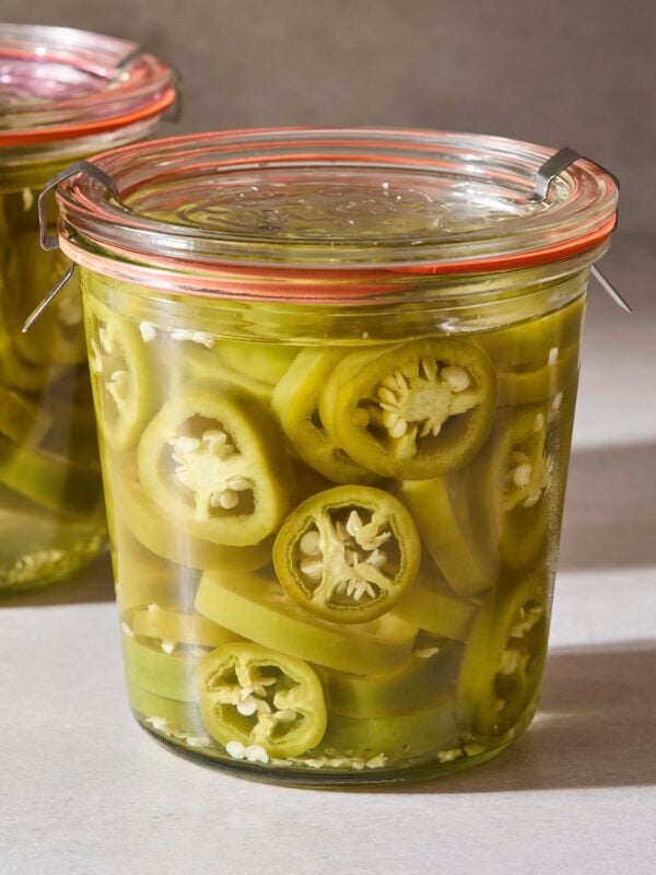 A jar filled with jalapeños after being quick pickled.