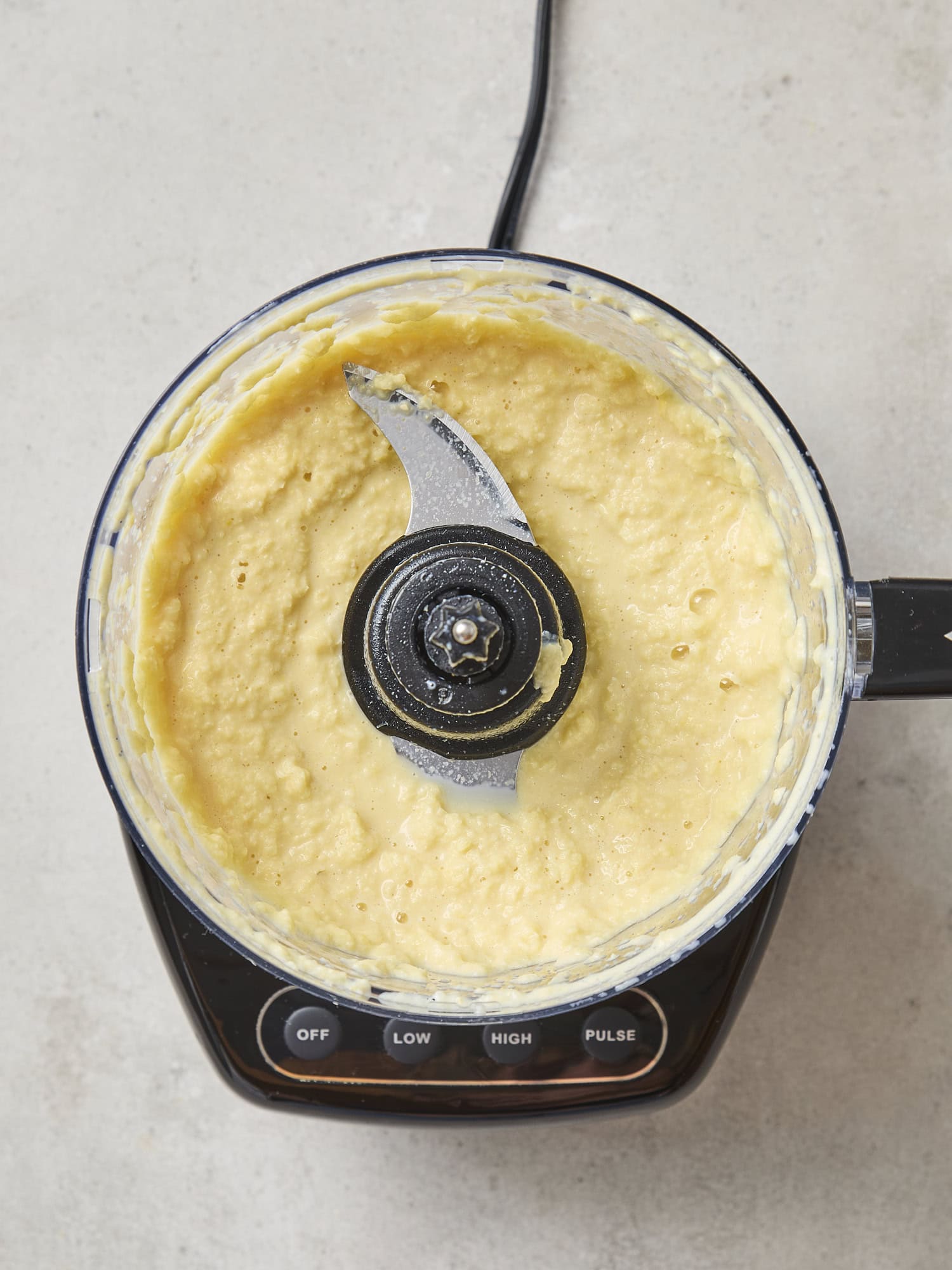 Food processor filled with pureed sweet corn.