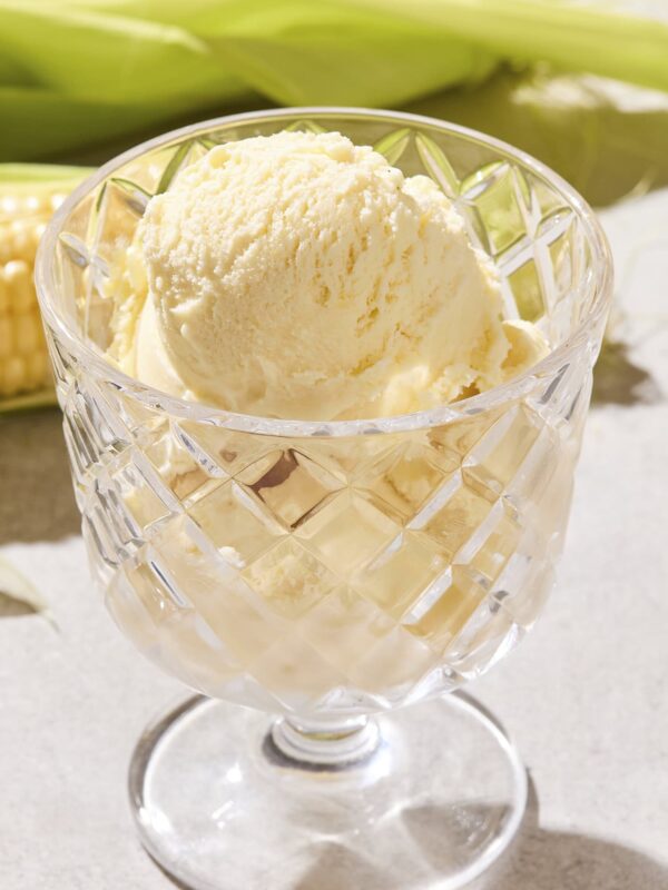 Glass filled with creamy yellow-colored sweet corn ice cream.