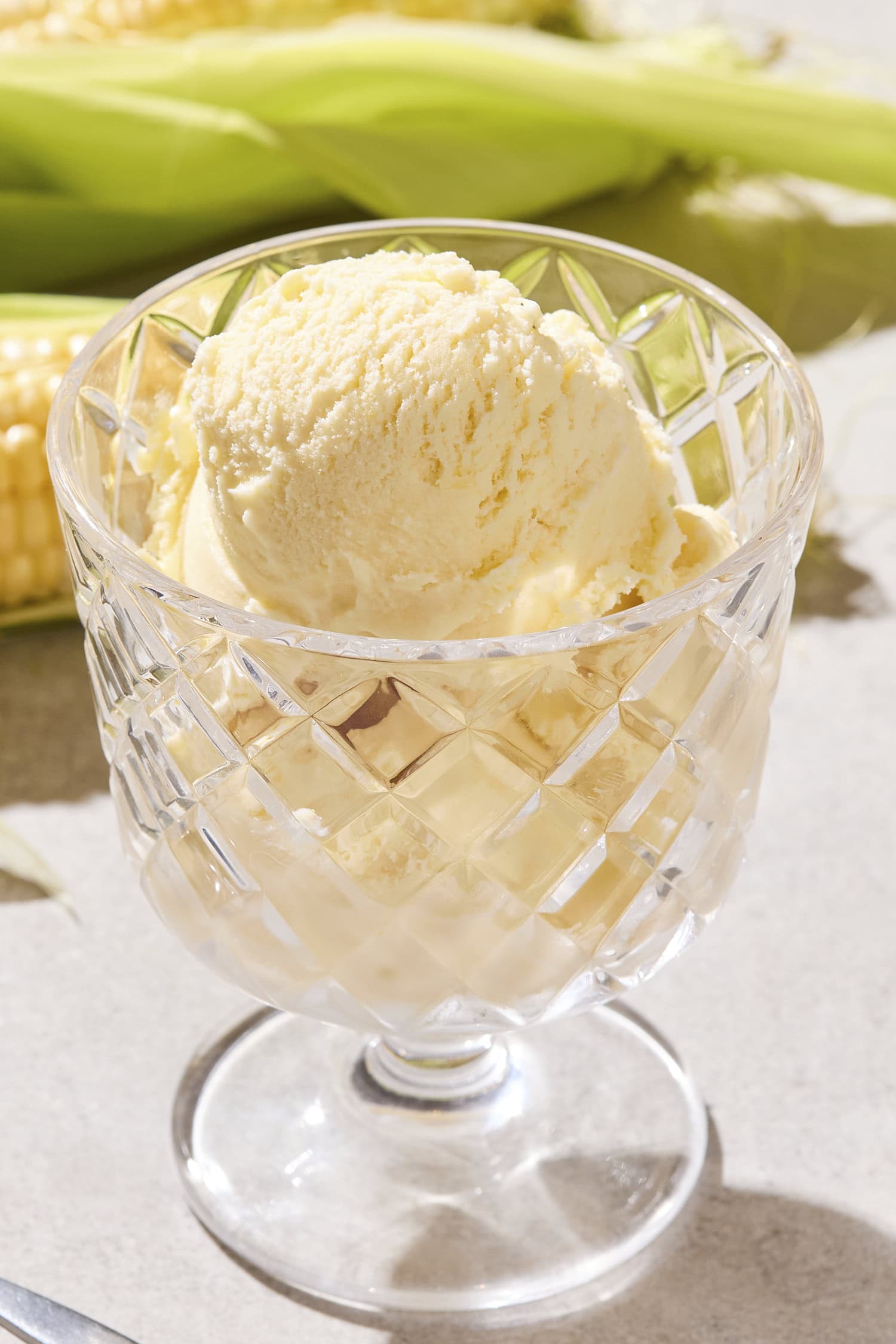 Glass filled with creamy yellow-colored sweet corn ice cream.