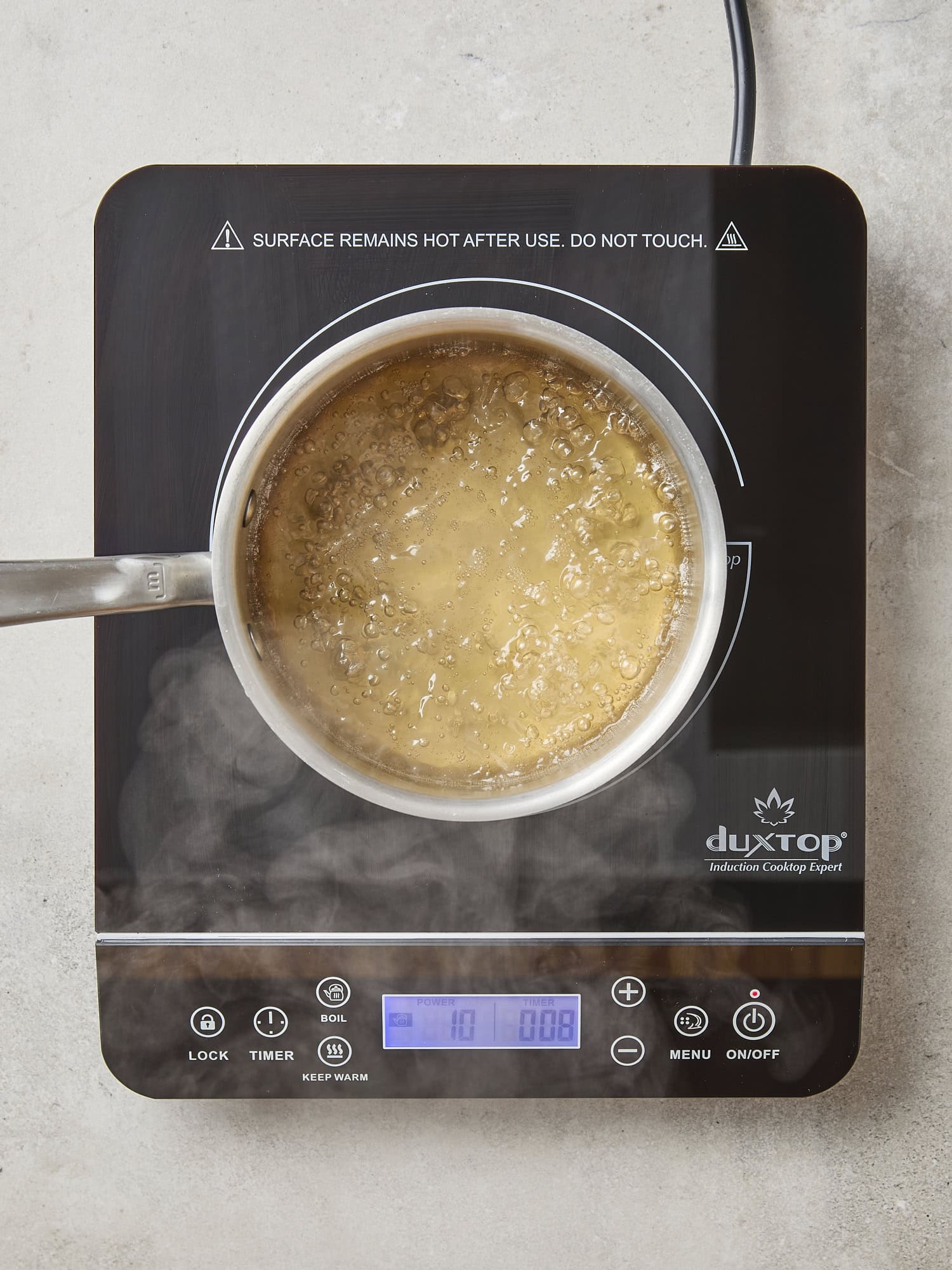 Apple cider vinegar brine heating on a hot plate.