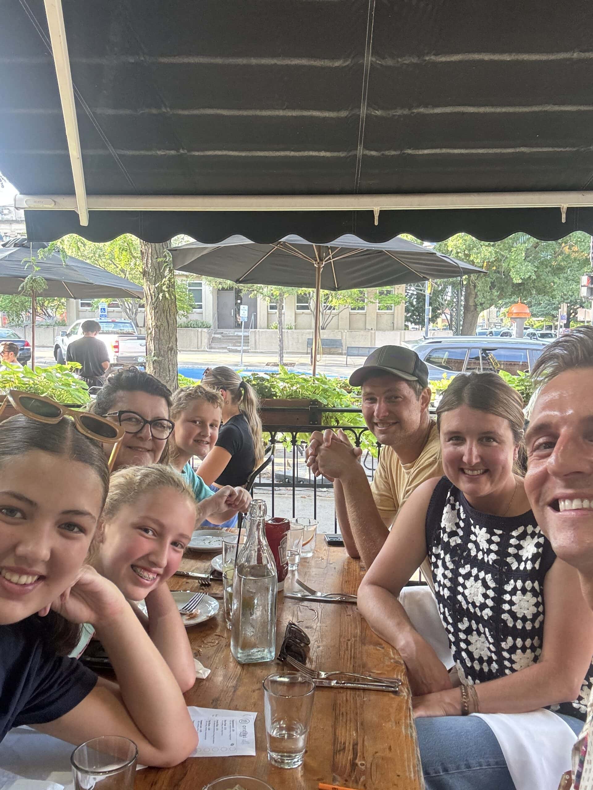 Kaleb Wyse with his whole family eating dinner outdoors at a restaurant.