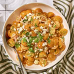 Bowl with yellow cherry tomatoes topped with feta cheese and parsley for a quick tomato salad.
