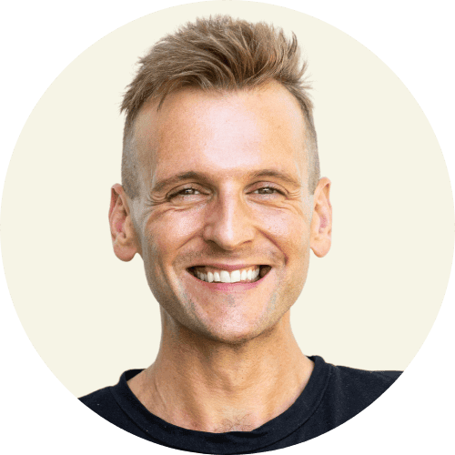 Kaleb Wyse wearing a black shirt standing in front of a taupe background.