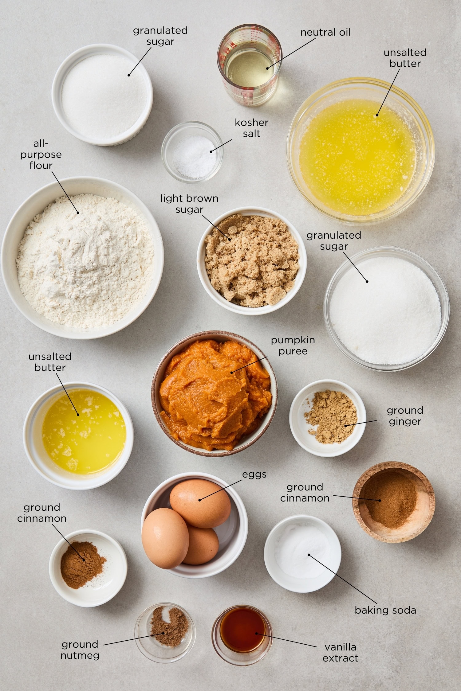 Concrete surface with ingredients to make baked pumpkin donuts.