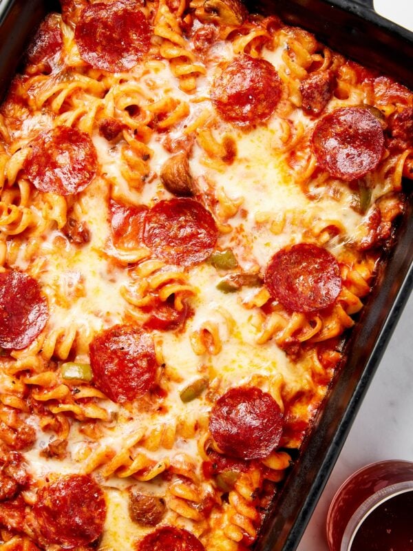 Black baking dish with pizza casserole inside topped with pepperonis.