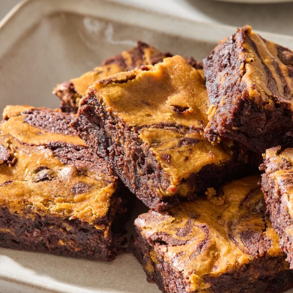 A platter with pumpkin cheesecake brownies topped with flaky salt.